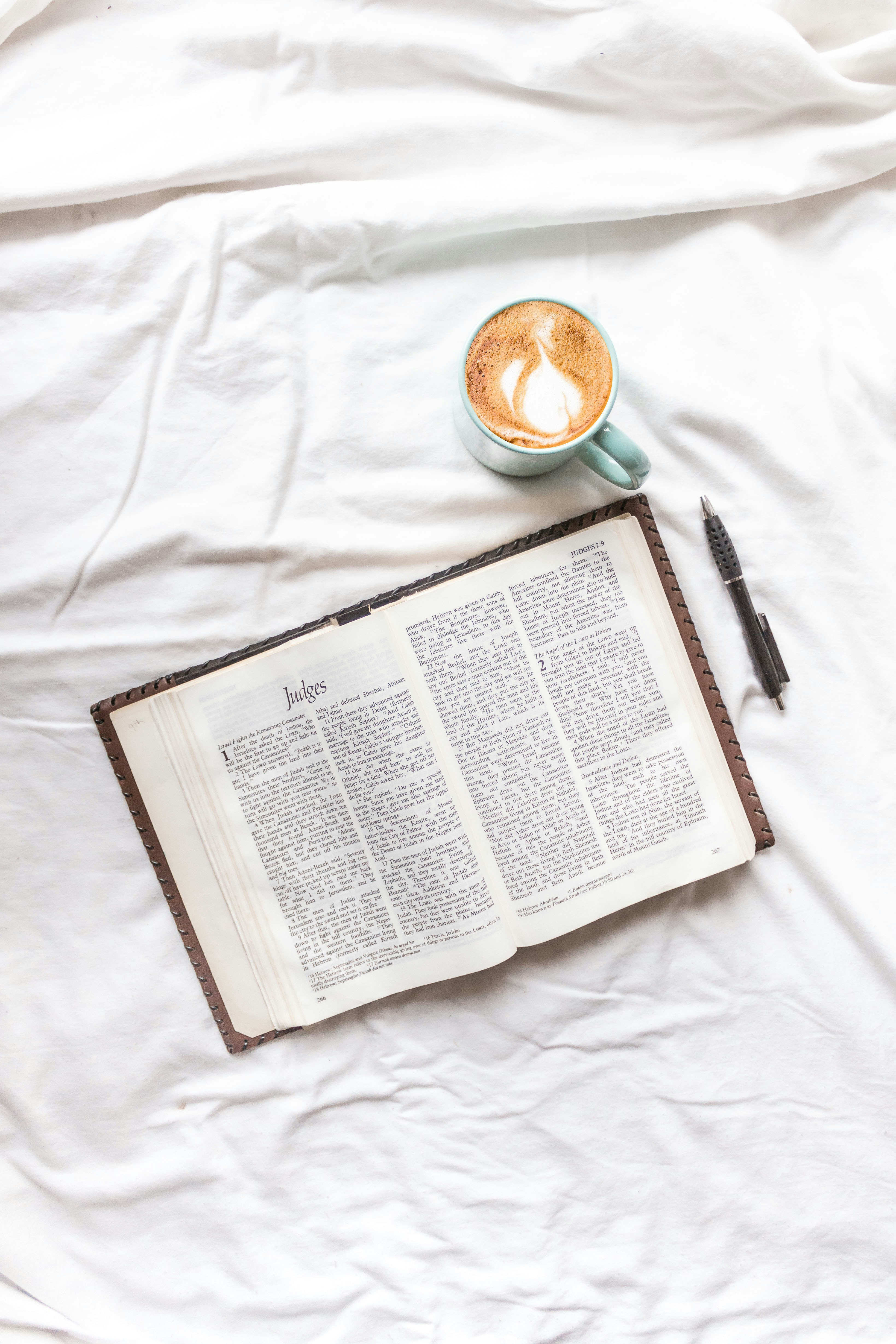 black pen on white textile beside white book